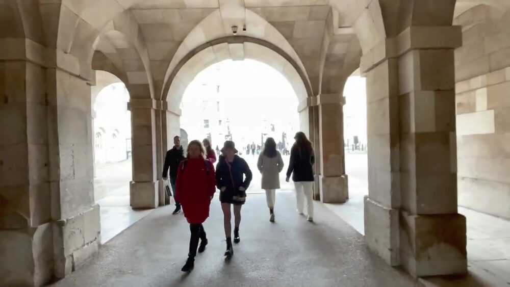 People walking through the stone archway at Horse Guards