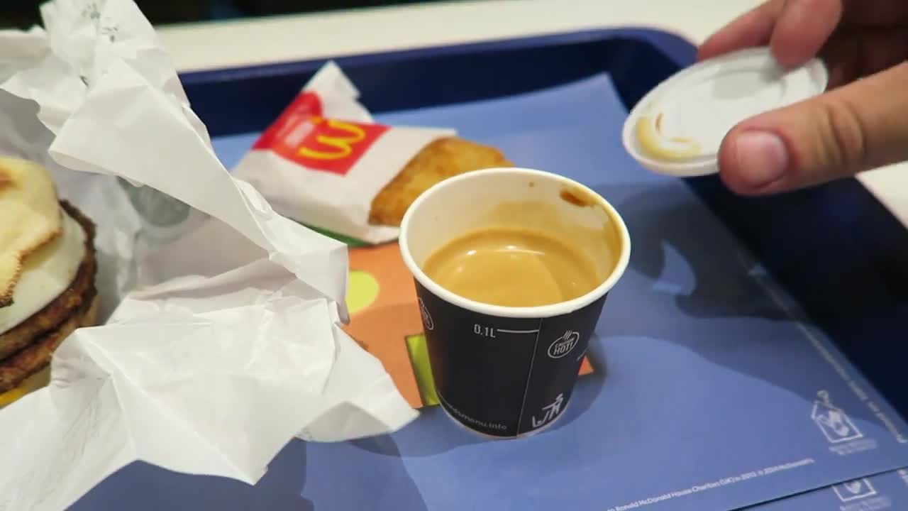 Espresso cup, hash brown and McMuffin on a breakfast tray