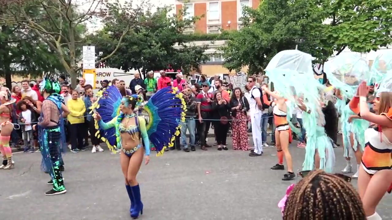 Costumed dancers passing spectators at Notting Hill Carnival 2018