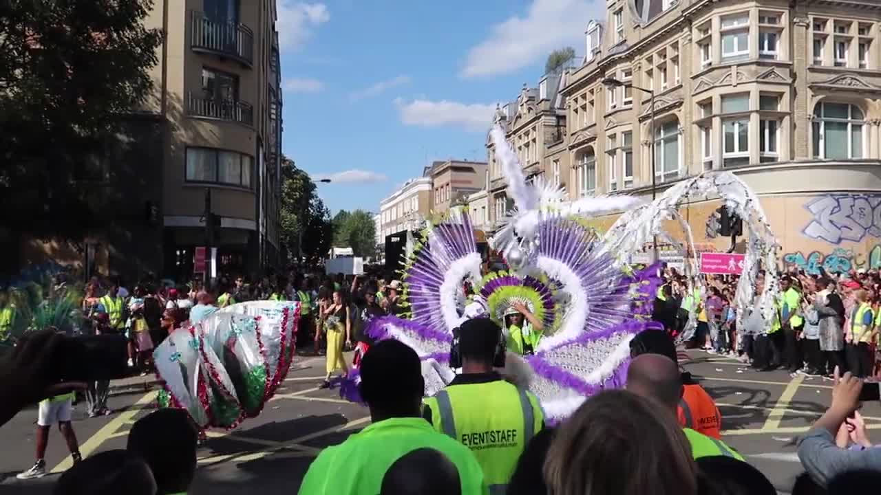 Carnival performer with a large purple and white feathered costume