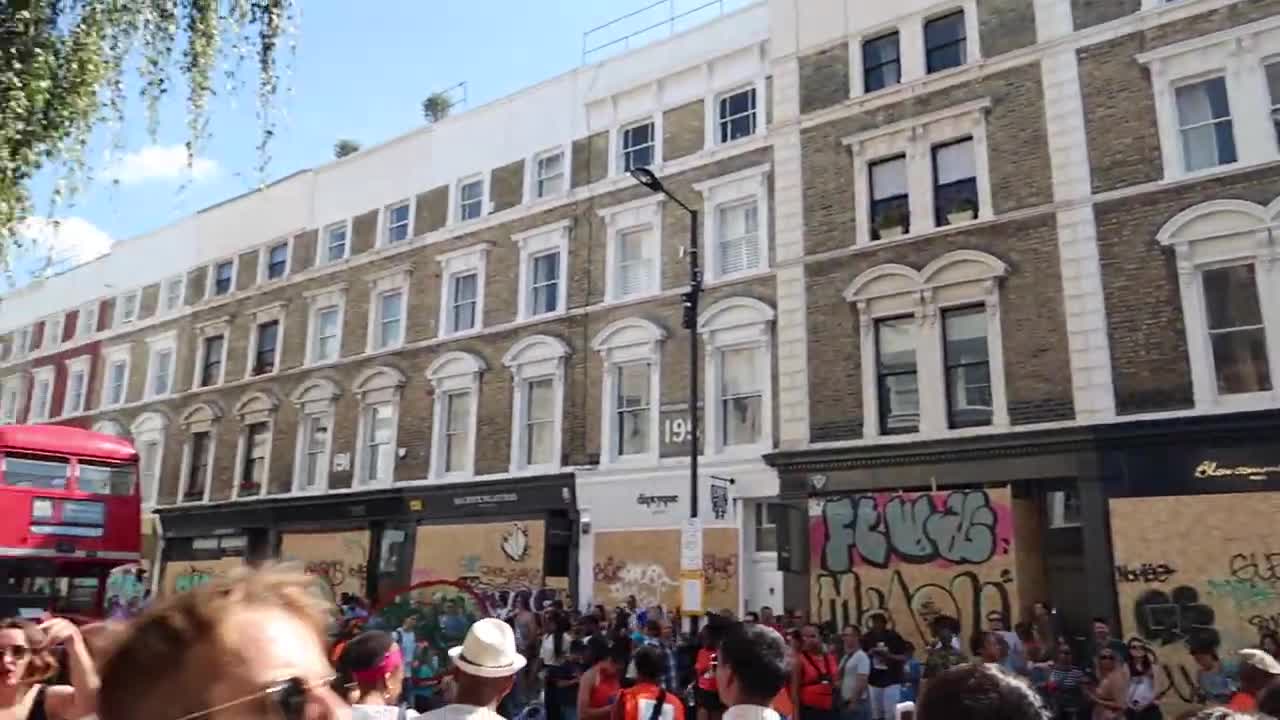Crowds gathered beside a sound system and boarded shopfronts in Notting Hill