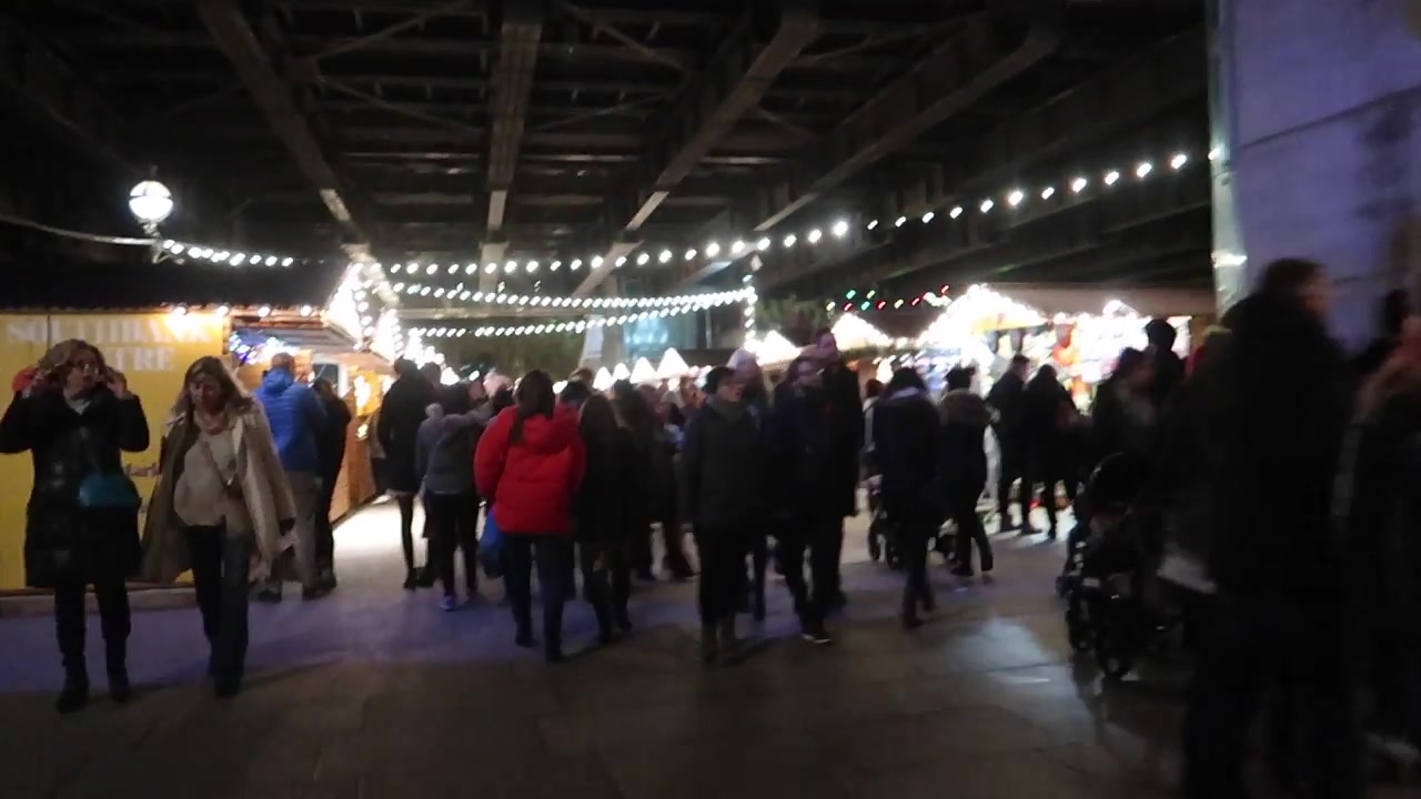 Christmas market huts and strings of lights beneath the railway bridge on the South Bank.