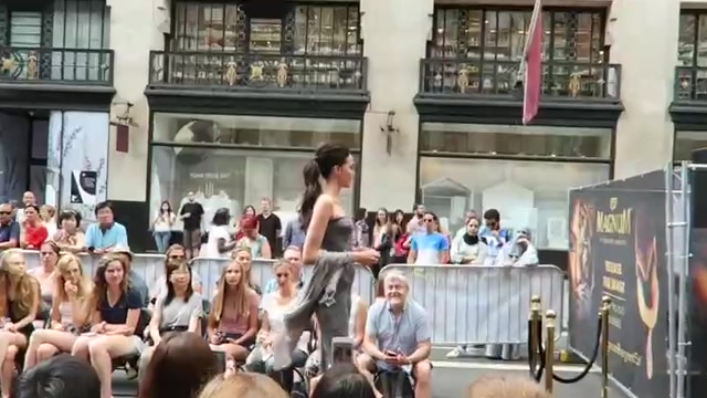 Model walking past seated spectators at the Regent Street outdoor fashion show