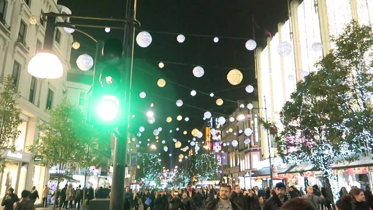 Glowing spherical decorations suspended above Oxford Street’s evening crowds.