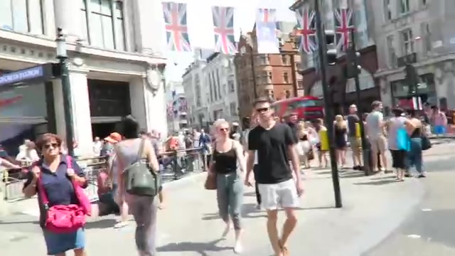 Shoppers crossing Oxford Circus beside red buses in 2016