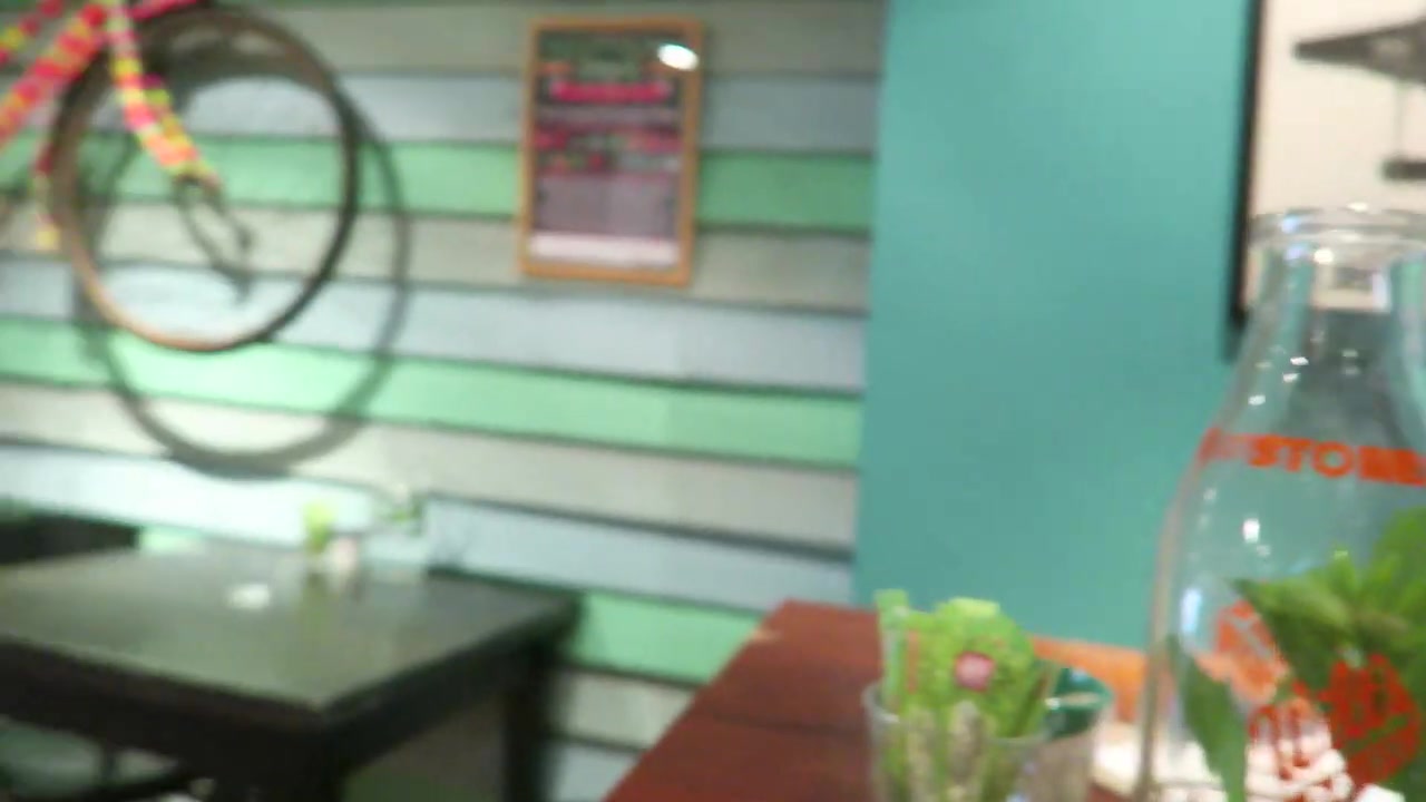 Plants and glass bottles on a table inside the Pedlars café in Notting Hill