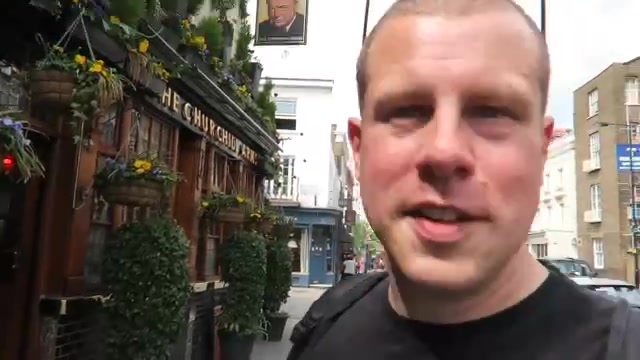 Barry outside the Churchill Arms with plants and hanging baskets behind him