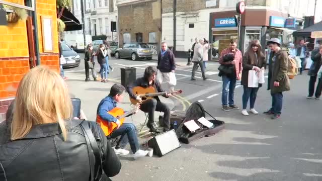Musicians performing beside the busy market street