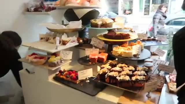 Cakes and pastries displayed on stands inside Ottolenghi