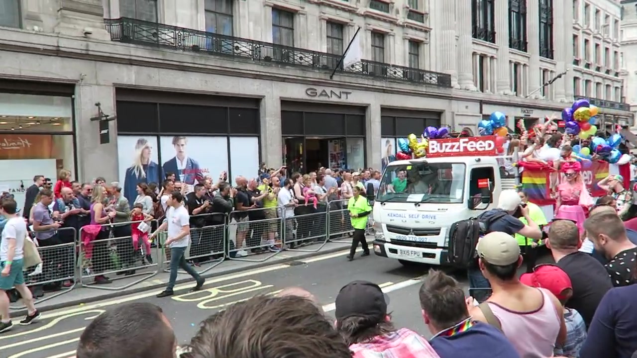 BuzzFeed parade float with rainbow flags and colourful balloons