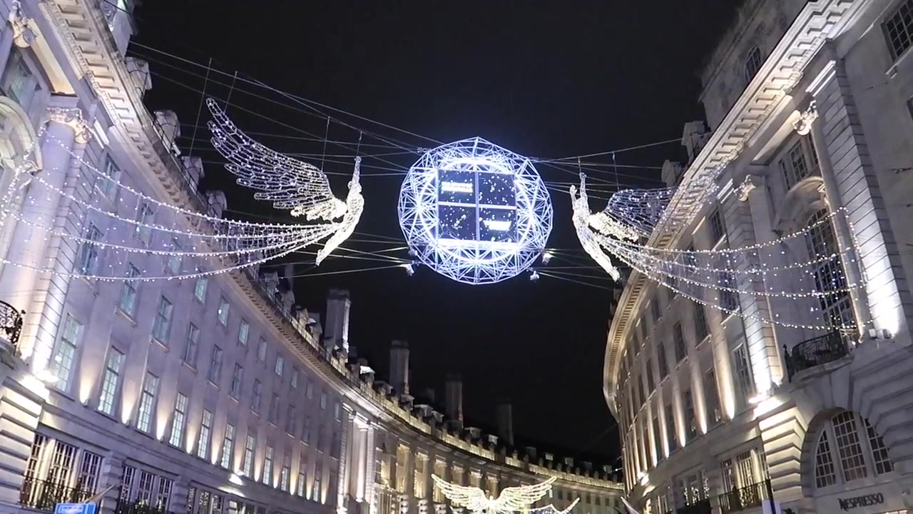 Winged decorations and a blue illuminated globe over the street.