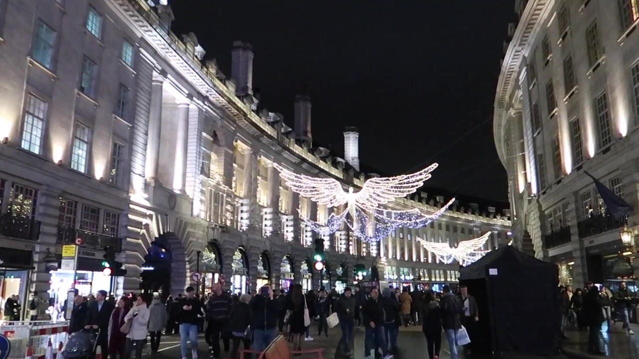 Crowds walk beneath the Christmas lights along Regent Street.