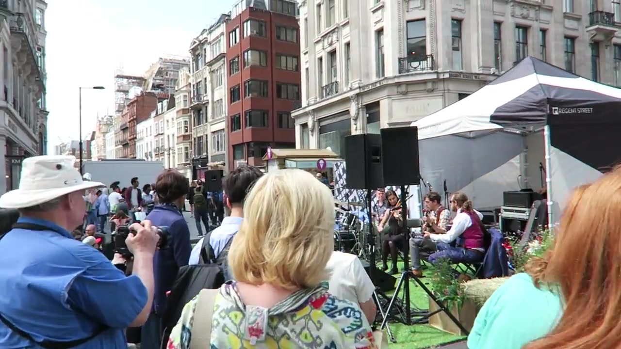 Visitors seated beside the outdoor stage at the Regent Street garden party