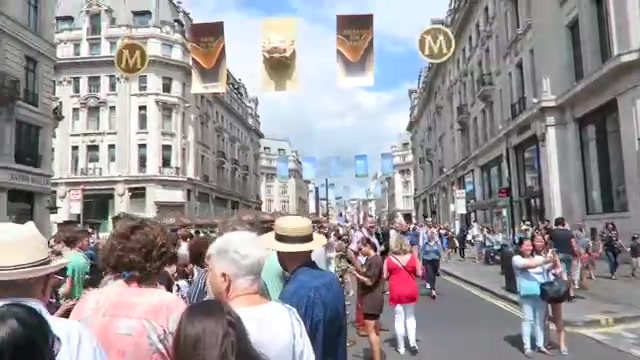 People walking beneath Magnum banners on Regent Street during Summer Streets 2016