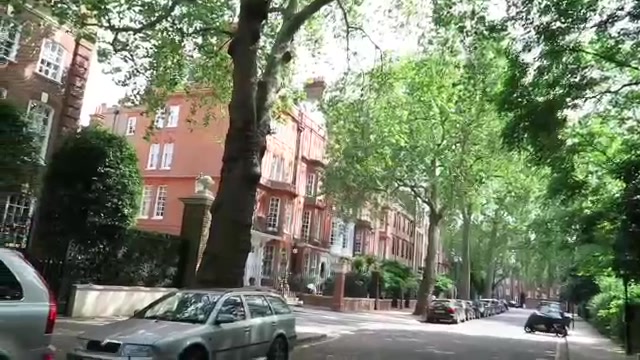 Tree-lined Cheyne Walk with red-brick houses in Chelsea