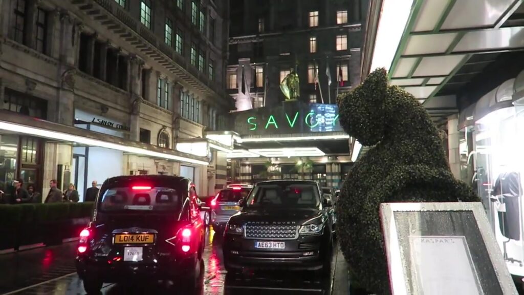 The Savoy Hotel entrance illuminated on the rain-soaked Strand in December 2016