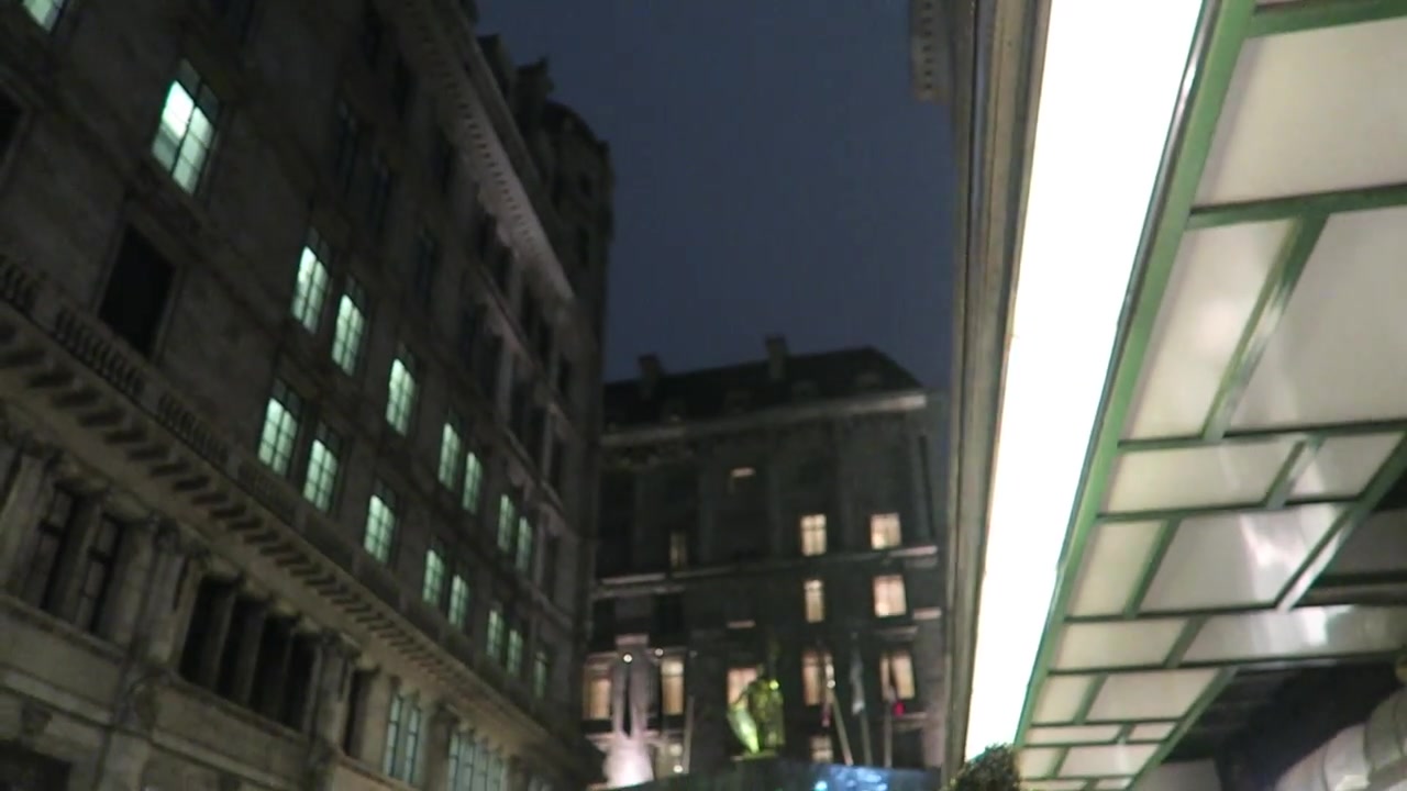 The Savoy Hotel frontage seen from beneath its illuminated Strand canopy at night