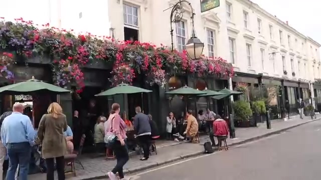 The Warwick Castle pub exterior with hanging flower baskets