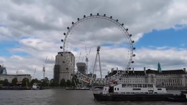 The London Eye across the Thames with a riverboat in the foreground