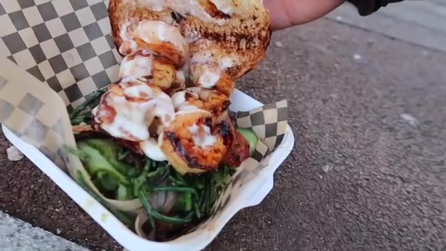 Shrimp burger with salad, avocado and bacon in a takeaway tray
