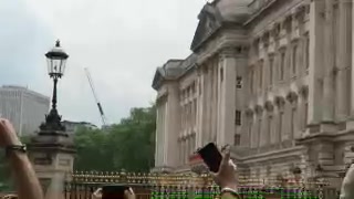 Buckingham Palace and its gates viewed over the heads of spectators