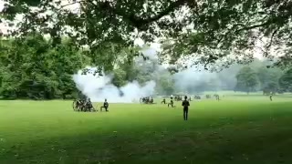 Smoke rising from the gun salute across the grass in Green Park
