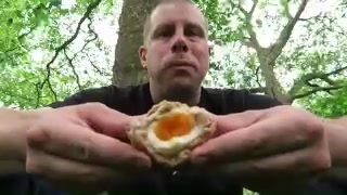 Barry holding a cut Scotch egg with a soft yolk during his Green Park picnic