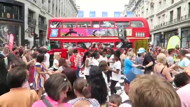 Crowds gathered around a red double-decker bus on Regent Street