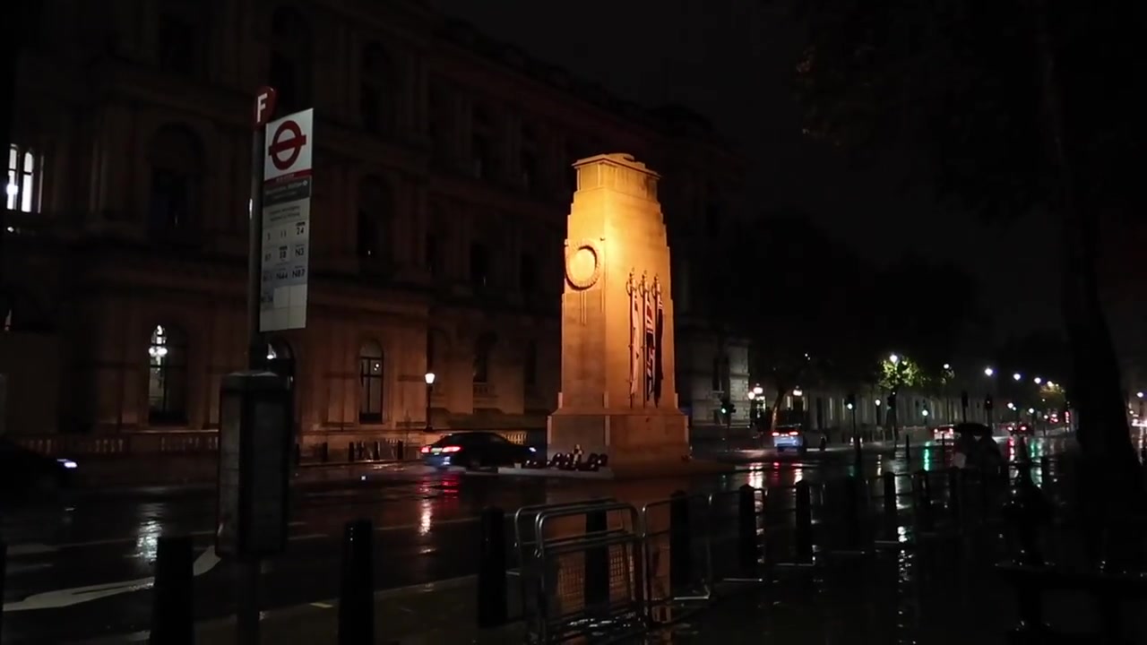 The illuminated Cenotaph on rain-soaked Whitehall at night