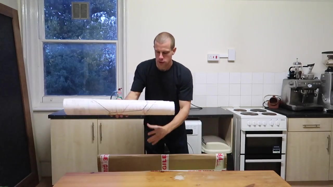 Barry unrolling the Tube map poster on a kitchen table