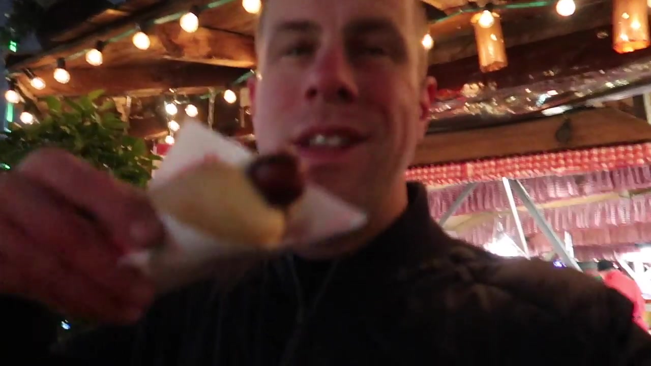 Barry holding a bratwurst in a roll at Winter Wonderland