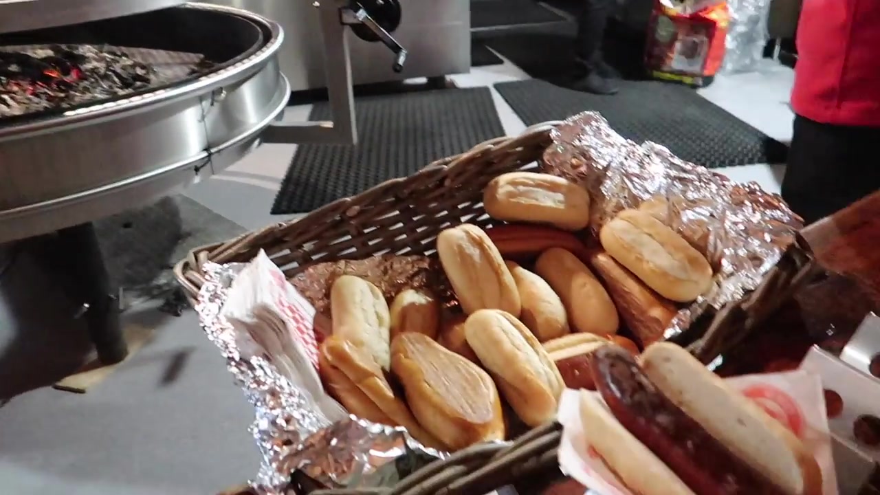 Grilled bratwurst in a bread roll beside the barbecue counter