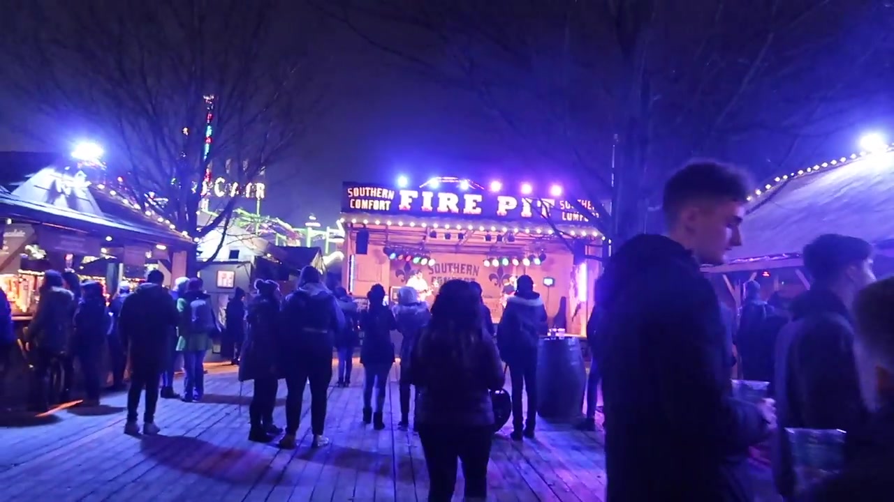 Visitors outside the illuminated Fire Pit bar at Winter Wonderland