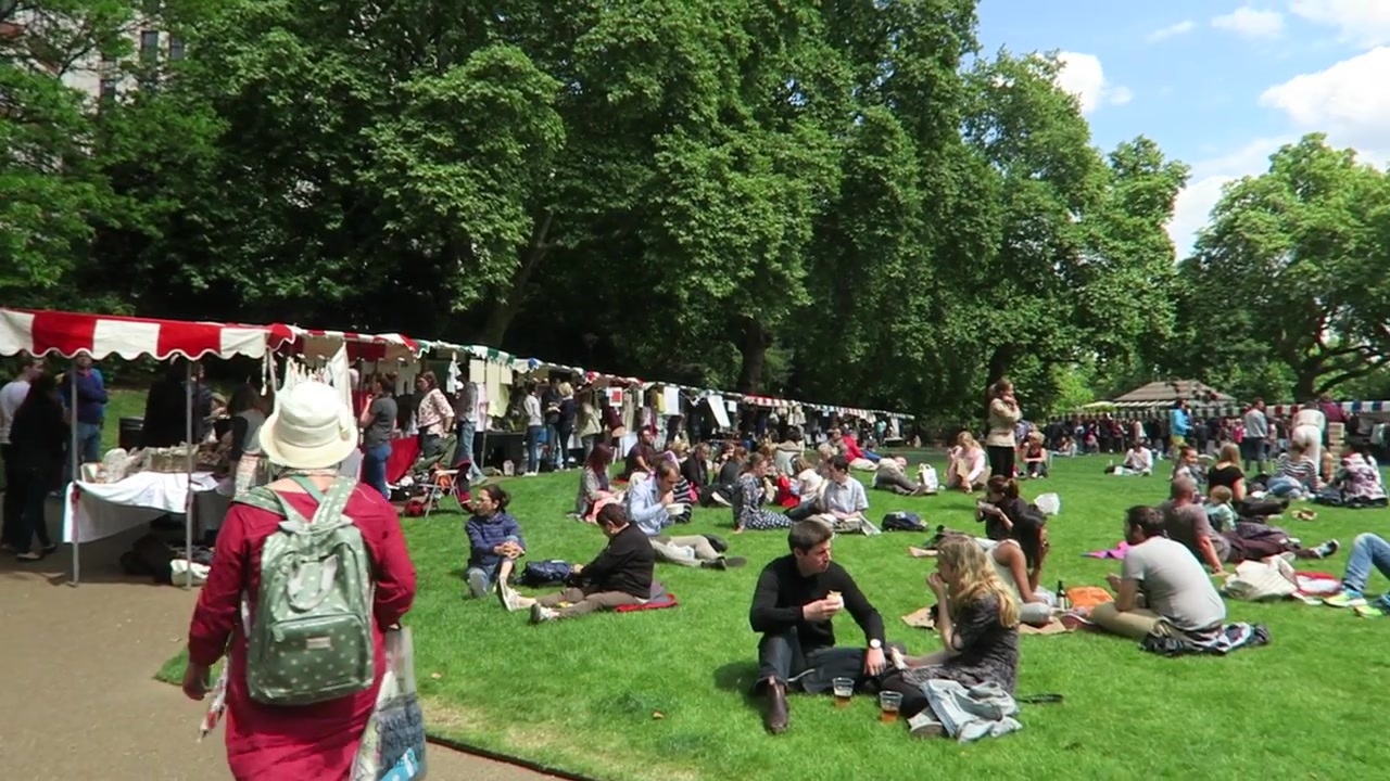 Visitors relaxing on the lawn beside stalls at Embankment Summer Market in 2015.