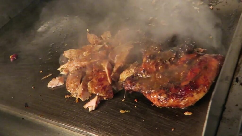 Jerk chicken cooking on the griddle at Mama’s Jerk, Pop Brixton