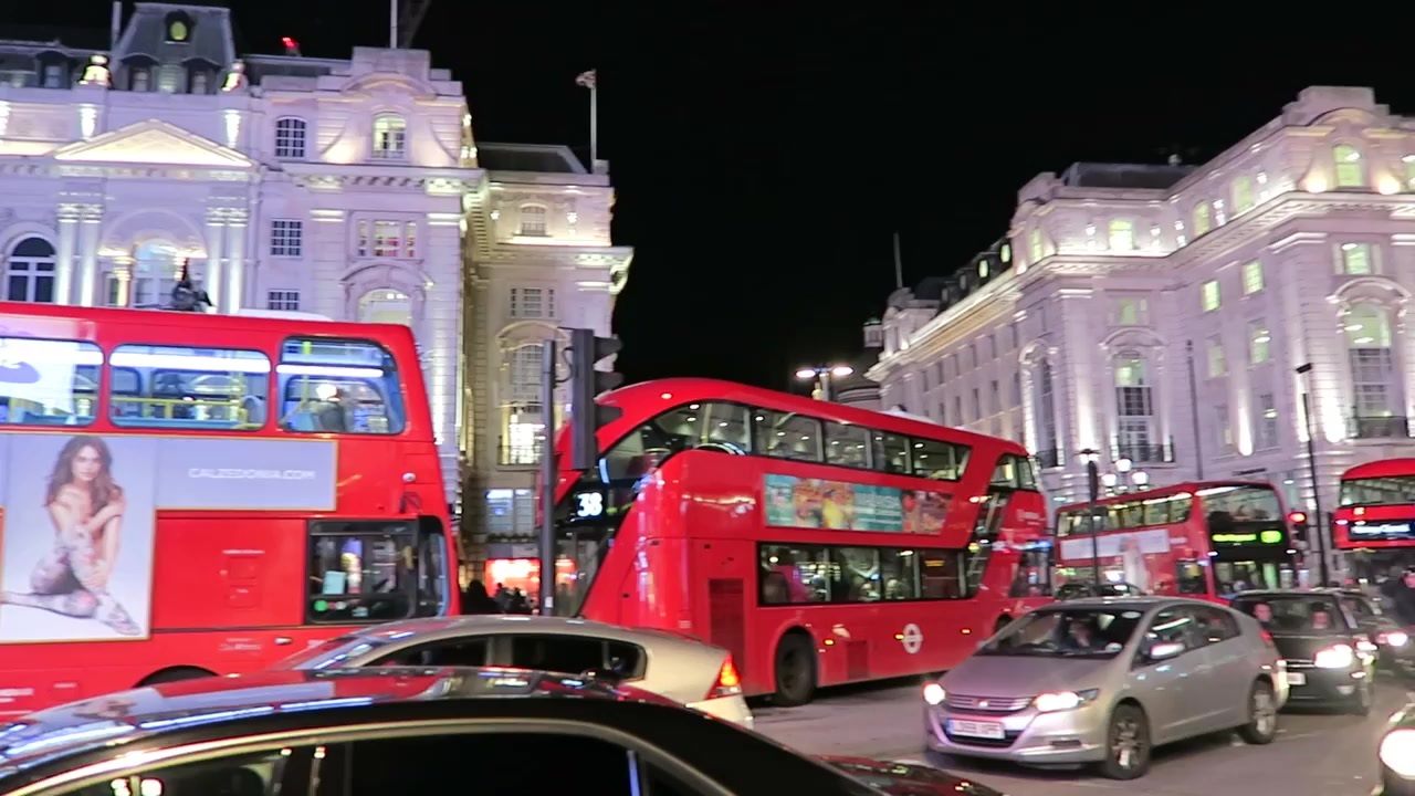 Red buses and illuminated buildings at Piccadilly Circus at night