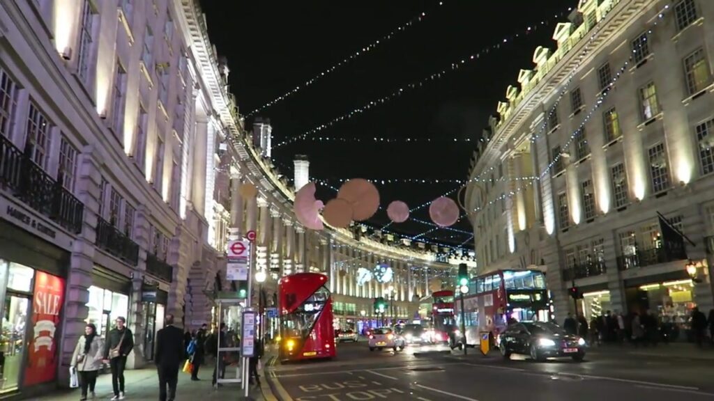 Circular Christmas decorations above Regent Street with buses and illuminated buildings