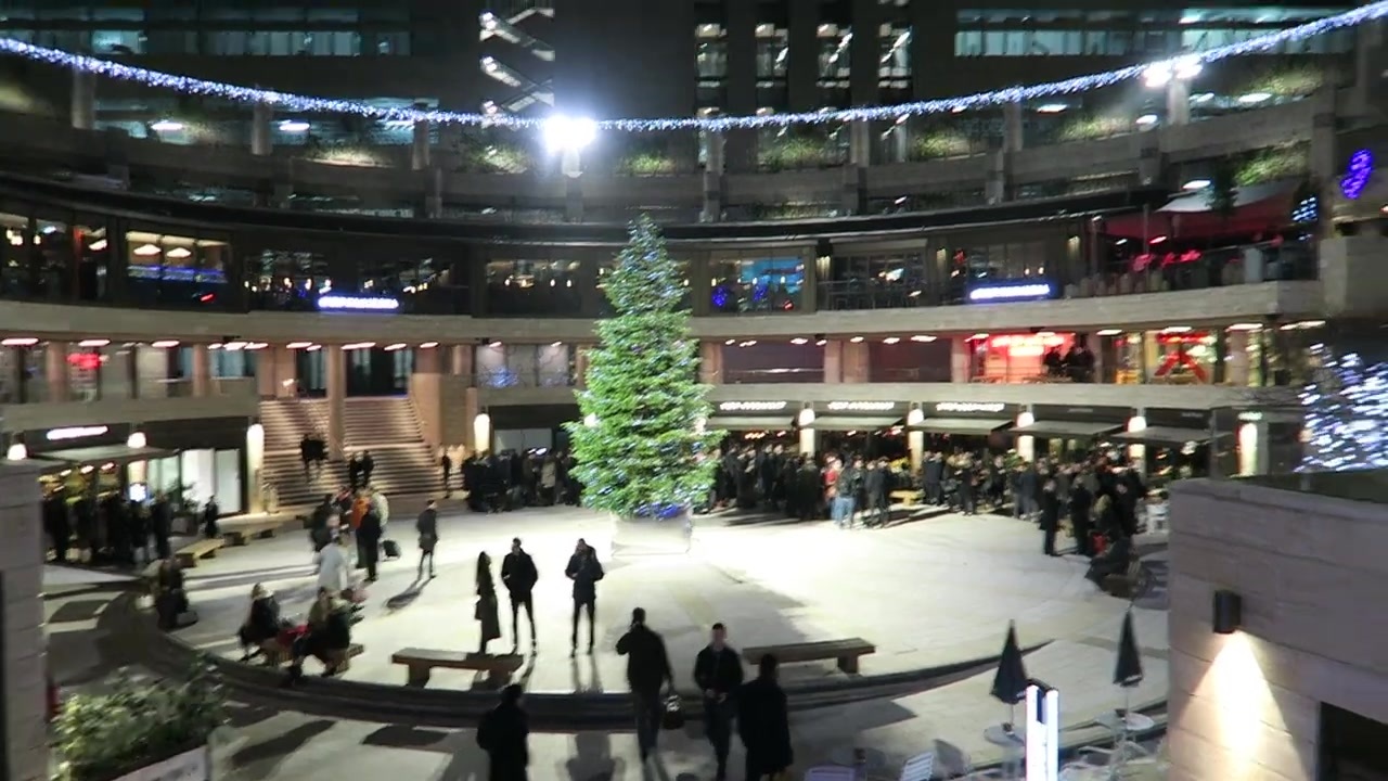 Broadgate Circle at night with a Christmas tree and restaurants around the central space.