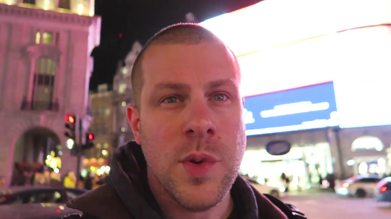 Barry at Piccadilly Circus with illuminated advertising behind him