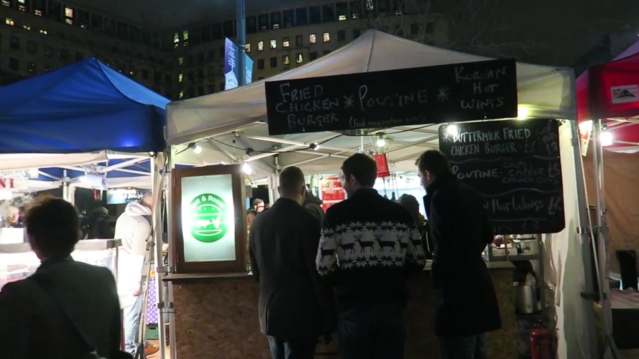 Visitors at the illuminated Southbank Centre Food Market stalls in December 2015