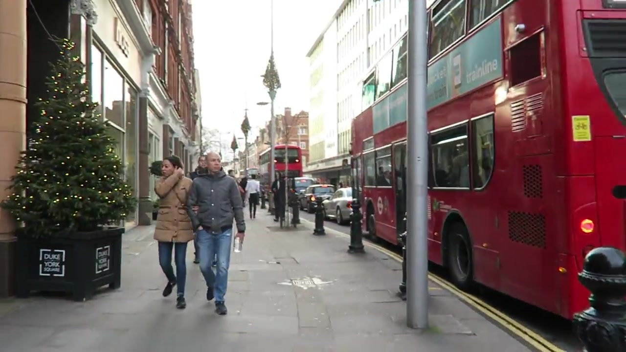 Christmas trees and a red bus on a Chelsea shopping street