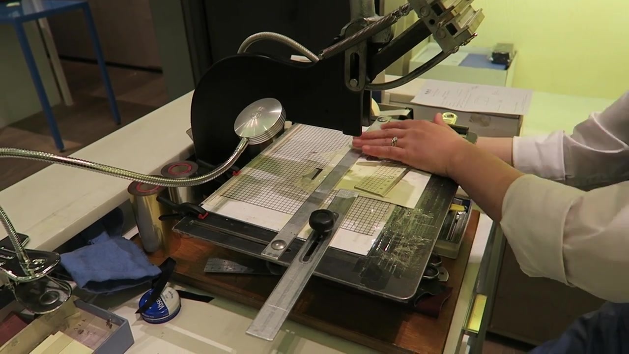 The card holder being personalised at the in-store embossing workbench.