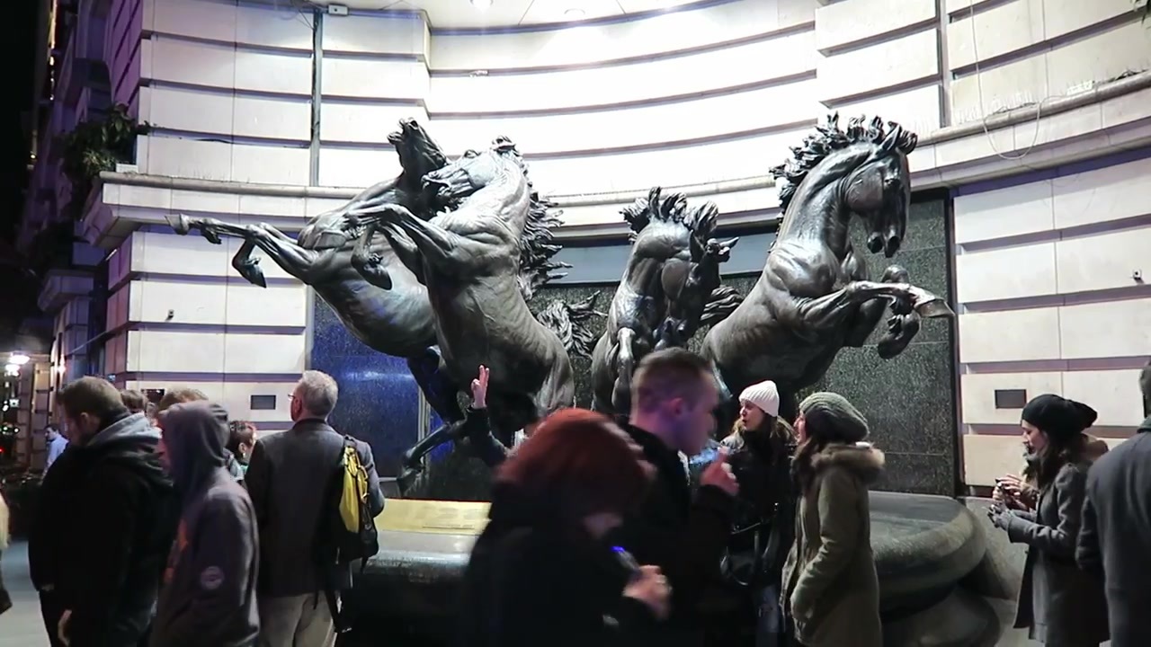 Horse sculpture and people beside the buildings at Piccadilly Circus