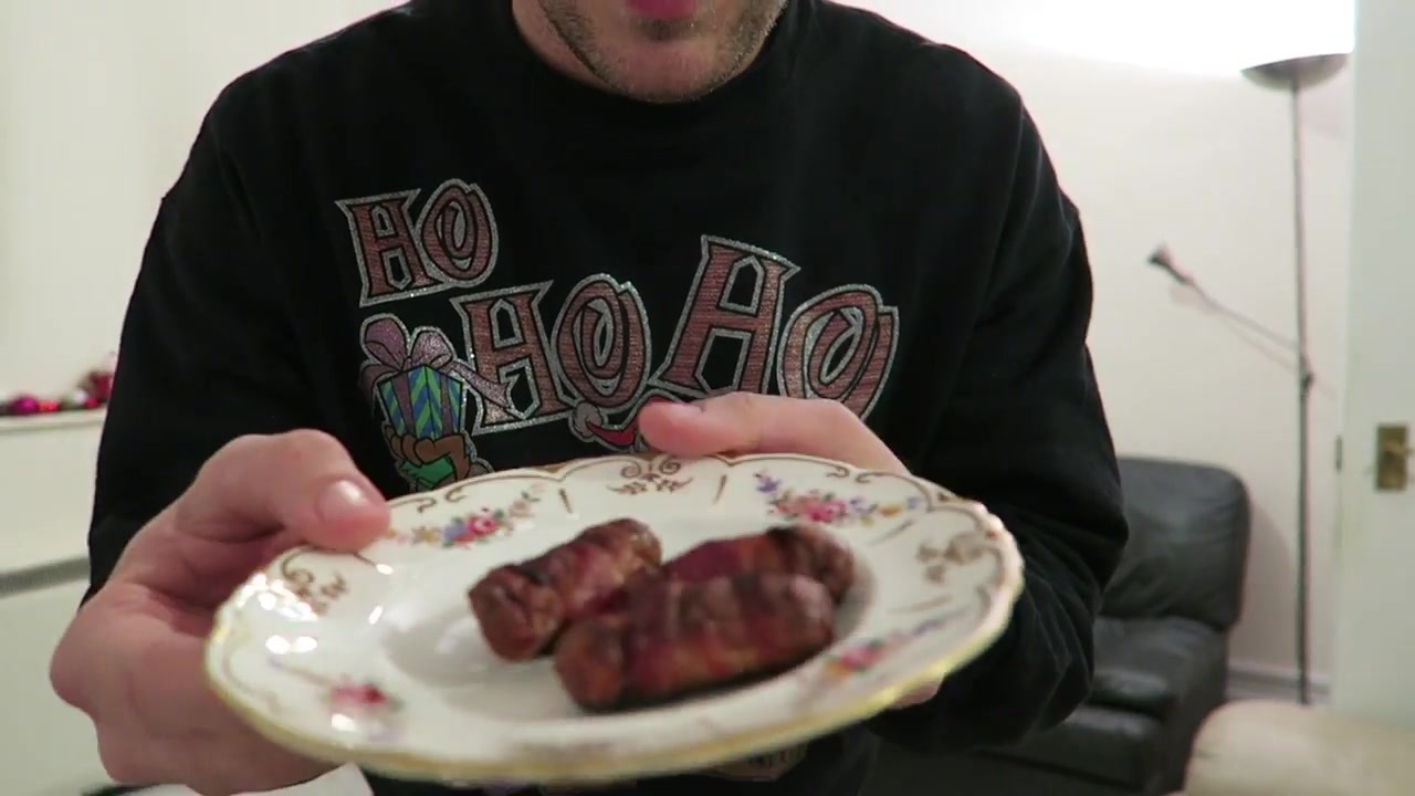 Bacon-wrapped cocktail sausages with tomato ketchup on a plate.