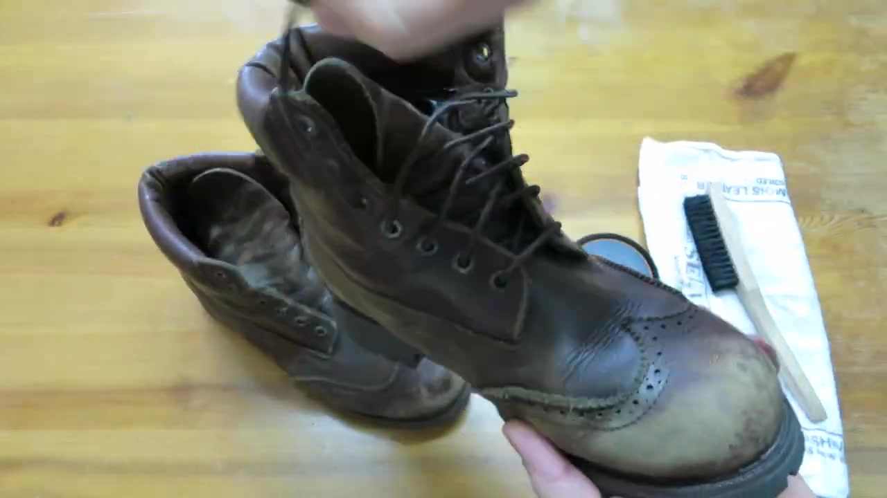 Worn brown leather boot with a pale scuffed toe before treatment