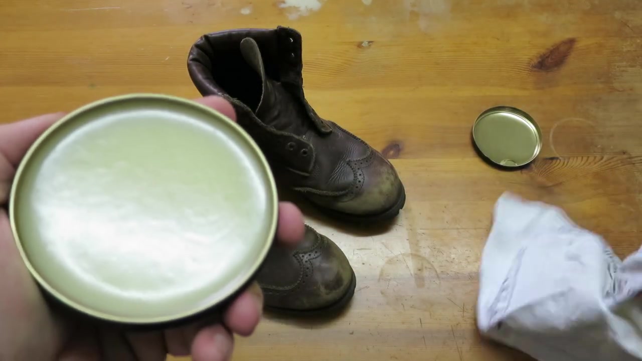 Open tin of pale Timberland Waximum wax held above the table