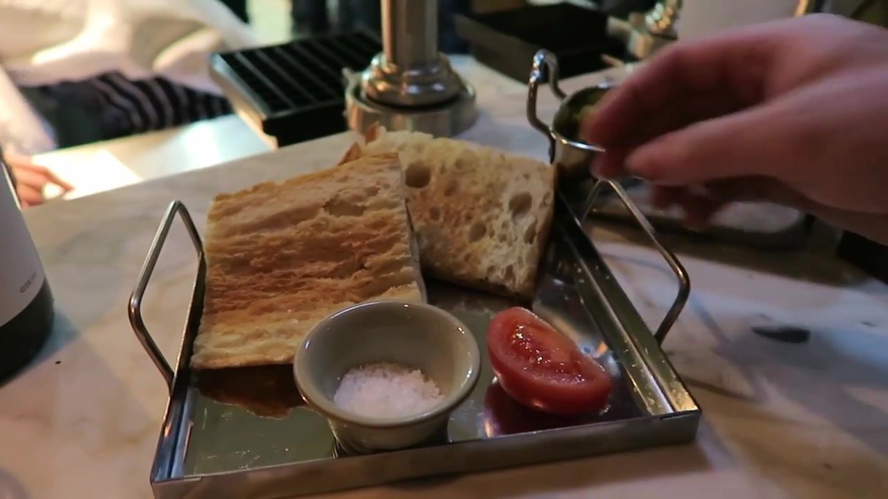 Bread, tomato and a small dish of salt at the restaurant counter