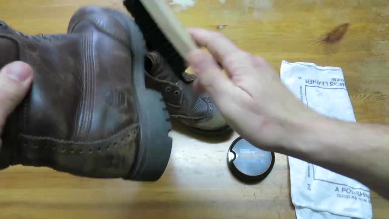 Brush cleaning the back of a brown leather boot