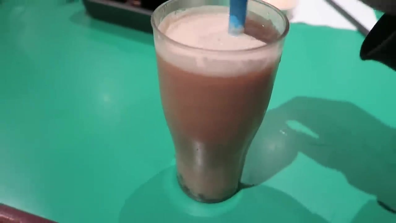 Coconut bubble tea with tapioca pearls on a green cafe table
