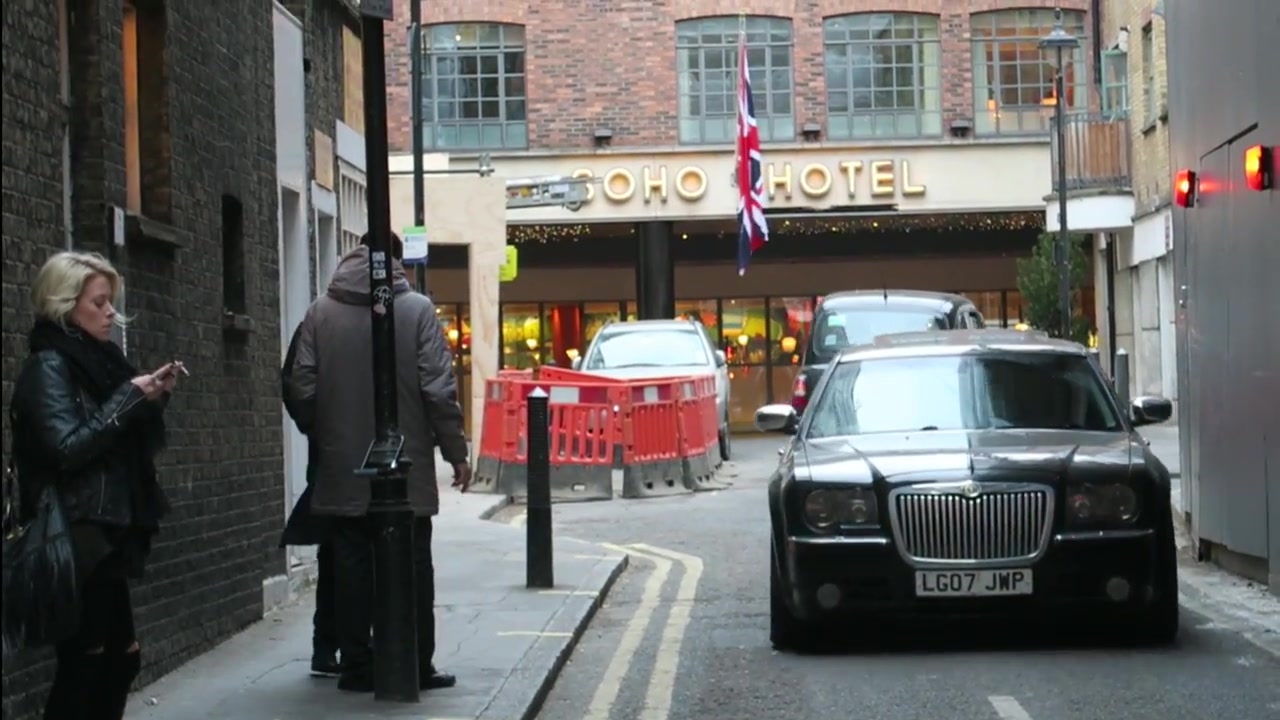 Black taxi in a Soho street with the Soho Hotel sign in the distance
